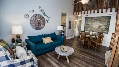 a living room with a blue couch and a table at Horizon South 33D - Sunstead Retreat - Sleeps 6 in Panama City Beach