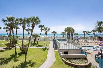 a view of a resort with palm trees and the beach at Summit 225 - Low floor beachfront - Sleeps 5 in Panama City Beach