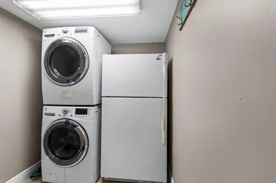 a laundry room with a washer and a refrigerator at Gulf Peak Retreat - Watercrest 2 BR 2 BA - Sleeps in Panama City Beach