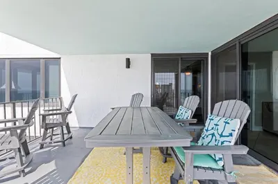 a wooden table and chairs on a balcony at Gulf Peak Retreat - Watercrest 2 BR 2 BA - Sleeps in Panama City Beach