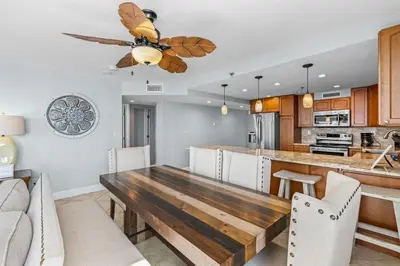 a kitchen with a wooden table and a ceiling fan at Gulf Peak Retreat - Watercrest 2 BR 2 BA - Sleeps in Panama City Beach