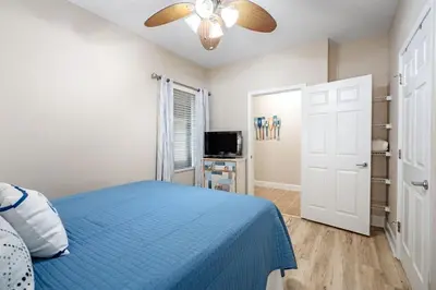 a bedroom with a blue bed and a ceiling fan at Tidewater 2411 - Tidewater Retreat - Sleeps 8 in Panama City Beach