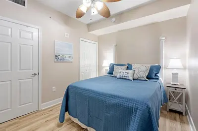 a bedroom with a blue bed and a ceiling fan at Tidewater 2411 - Tidewater Retreat - Sleeps 8 in Panama City Beach