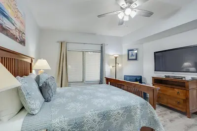 a bedroom with a bed and a flat screen tv at Shores of Panama 1403 - 3 BR 2 Ba Newly Renovated in Panama City Beach