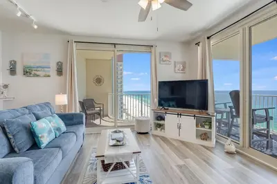 a living room with a blue couch and a flat screen tv at Shores of Panama 1403 - 3 BR 2 Ba Newly Renovated in Panama City Beach