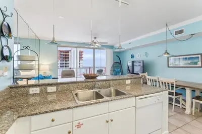 a kitchen with a sink and a table at Peak-Shore Overlook - Sleeps 8 in Panama City Beach
