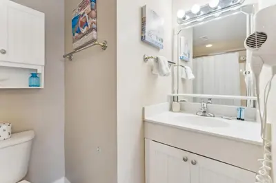 a white bathroom with a sink and a toilet at Peak-Shore Overlook - Sleeps 8 in Panama City Beach