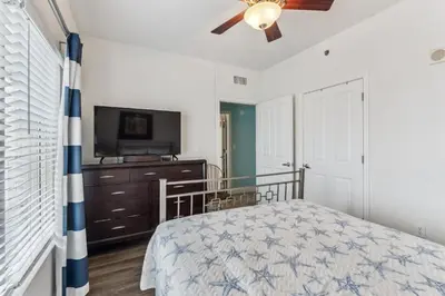 a bedroom with a bed and a flat screen tv at Peak-Shore Overlook - Sleeps 8 in Panama City Beach