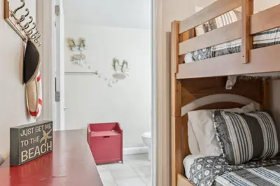 a bedroom with a bunk bed and a bathroom at Peak-Shore Overlook - Sleeps 8 in Panama City Beach
