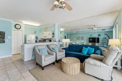 a living room with a blue couch and chairs at Peak-Shore Overlook - Sleeps 8 in Panama City Beach