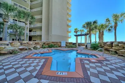a swimming pool in front of a building with palm trees at Shores of Panama 1307, Two Masters! in Panama City Beach