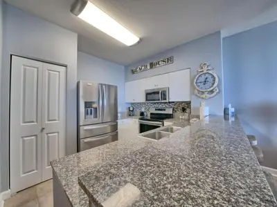 a kitchen with a counter top and a refrigerator at Shores of Panama 1307, Two Masters! in Panama City Beach