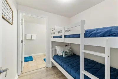 a bedroom with two bunk beds and a doorway at Shores of Panama 727 - Same level parking space! in Panama City Beach