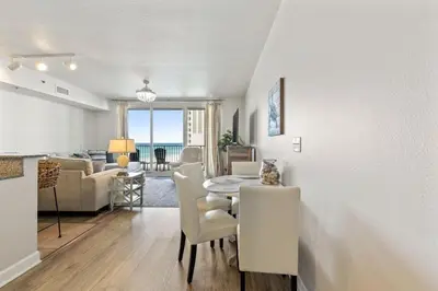a living room and dining room with a table and chairs at Shores of Panama 727 - Same level parking space! in Panama City Beach