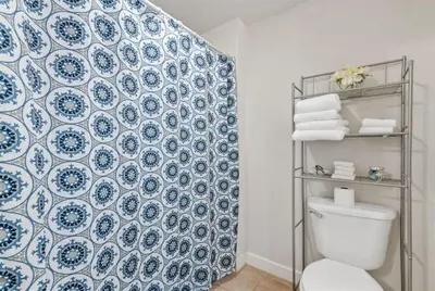 a bathroom with a blue and white patterned wall at Shores of Panama 727 - Same level parking space! in Panama City Beach
