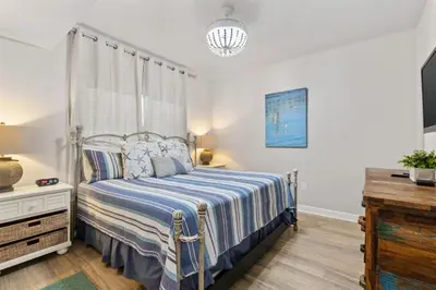 a bedroom with a bed with a blue and white comforter at Shores of Panama 727 - Same level parking space! in Panama City Beach
