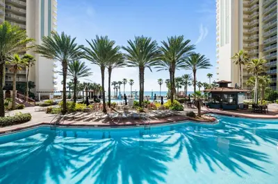a swimming pool at the resort with palm trees at Shores of Panama 727 - Same level parking space! in Panama City Beach
