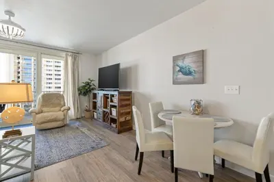 a living room with a dining area with a table and chairs at Shores of Panama 727 - Same level parking space! in Panama City Beach