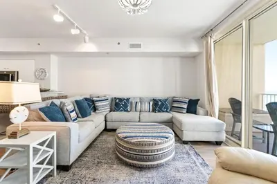 a living room with a couch and a table at Shores of Panama 727 - Same level parking space! in Panama City Beach
