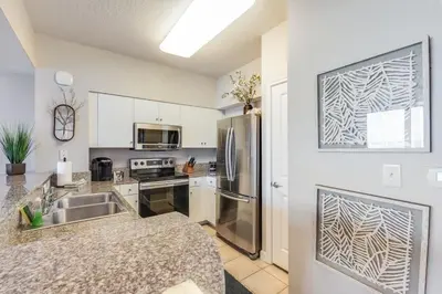 a kitchen with a sink and a stainless steel refrigerator at Shores of Panama 2115, 2BR 2 BA, sleeps 6 in Panama City Beach