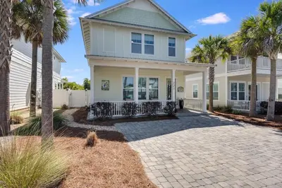 a house with palm trees in front of it at 221 Sands Street - 4 BR with Private pool in Panama City Beach