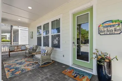 a front porch of a home with a green door at 221 Sands Street - 4 BR with Private pool in Panama City Beach