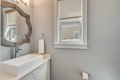 a bathroom with a sink and a mirror and a window at 221 Sands Street - 4 BR with Private pool in Panama City Beach