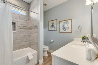 a white bathroom with a sink and a toilet at 221 Sands Street - 4 BR with Private pool in Panama City Beach