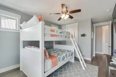 a white bunk bed in a room with a ceiling fan at 221 Sands Street - 4 BR with Private pool in Panama City Beach