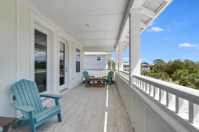 a porch with two blue chairs and a table at 221 Sands Street - 4 BR with Private pool in Panama City Beach