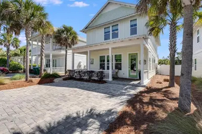 a house with palm trees in front of it at 221 Sands Street - 4 BR with Private pool in Panama City Beach