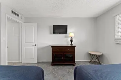 a bedroom with a bed and a television on a wall at Regency Towers 207 - Sleeps 8 -East-Gulf Overview in Panama City Beach