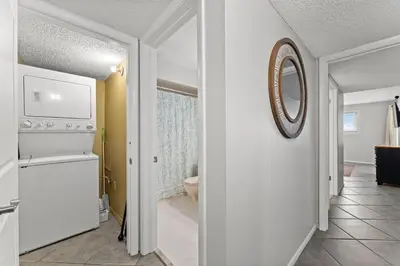 a kitchen with a white refrigerator and a mirror at Regency Towers 207 - Sleeps 8 -East-Gulf Overview in Panama City Beach