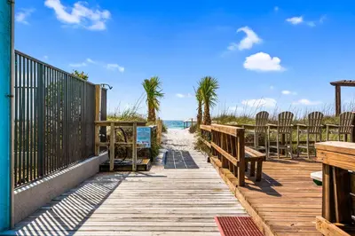 a wooden pathway to the beach with chairs and the ocean at Moondrifter 804 - Sleeps 6 - 2 BR 2 BA with bunks in Panama City Beach