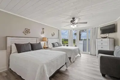 a bedroom with two beds and a ceiling fan at Top of the Gulf 120 - Shore-side Bungalow Sleeps 4 in Panama City Beach
