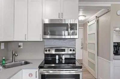 a kitchen with a stove and a microwave at Top of the Gulf 120 - Shore-side Bungalow Sleeps 4 in Panama City Beach