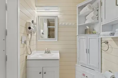 a bathroom with a sink and a mirror at Top of the Gulf 120 - Shore-side Bungalow Sleeps 4 in Panama City Beach