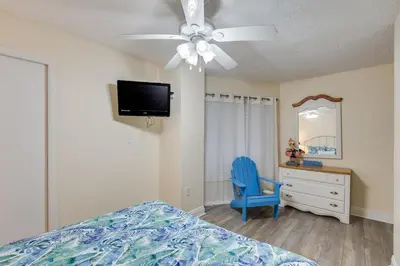 a bedroom with a bed and a dresser and a ceiling fan at Moondrifter 305 - 2 BR - Oceanfront condo Sleeps 6 in Panama City Beach