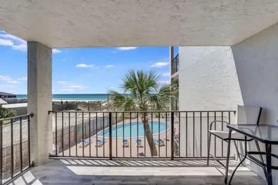 a balcony with a view of a pool and the ocean at Moondrifter 305 - 2 BR - Oceanfront condo Sleeps 6 in Panama City Beach