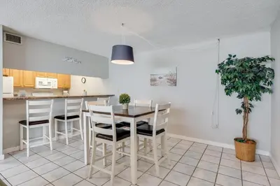 a kitchen with a dining room table and chairs at Moondrifter 604 - Emerald Gulf Retreat - Sleeps 6 in Panama City Beach