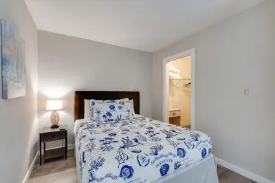 a bedroom with a blue and white bed and a lamp at Moondrifter 604 - Emerald Gulf Retreat - Sleeps 6 in Panama City Beach