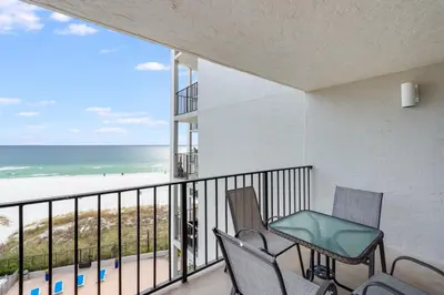 a balcony with two chairs and a view of the beach at Moondrifter 604 - Emerald Gulf Retreat - Sleeps 6 in Panama City Beach