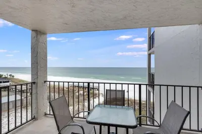 a balcony with a table and chairs and the ocean at Moondrifter 604 - Emerald Gulf Retreat - Sleeps 6 in Panama City Beach
