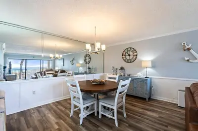 a dining room and kitchen with a table and chairs at Moondrifter 205 - Sand-Side Oasis - Sleeps 6 in Panama City Beach