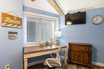 a desk in a room with a window and a clock at Moondrifter 205 - Sand-Side Oasis - Sleeps 6 in Panama City Beach