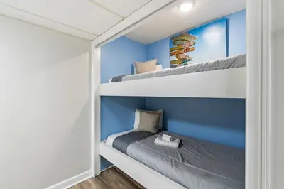 two bunk beds in a room with blue walls at Moondrifter 205 - Sand-Side Oasis - Sleeps 6 in Panama City Beach