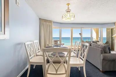 a dining room with a table and chairs with a view of the ocean at Long Beach Tower 2 #703 Beachfront 2 BR 2 BA in Panama City Beach