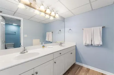 a bathroom with a sink and a large mirror at Long Beach Tower 2 #703 Beachfront 2 BR 2 BA in Panama City Beach