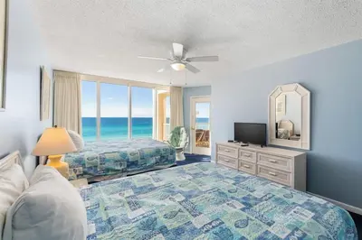 a bedroom with a bed and a mirror and a television at Long Beach Tower 2 #703 Beachfront 2 BR 2 BA in Panama City Beach