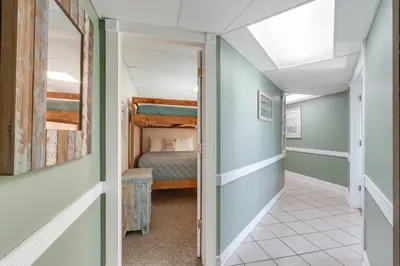 a hallway leading to a bedroom with a bunk bed at Sand-Crest Overlook - Moondrifter 201 in Panama City Beach